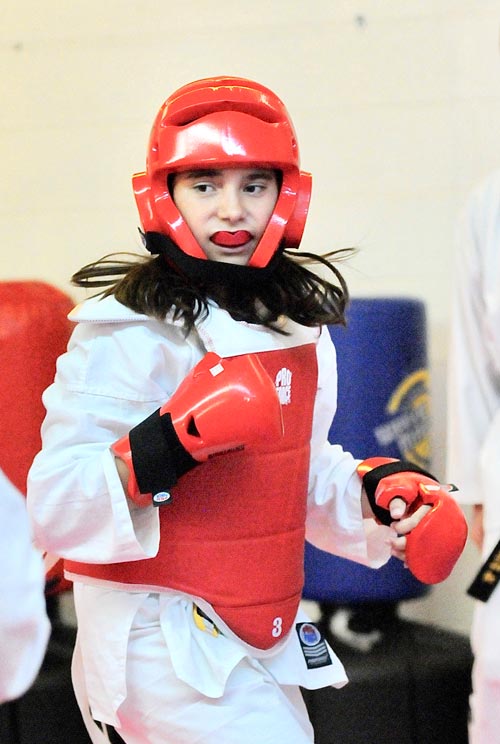 A Taekwondo students stands in a fighting stance during a sparring match